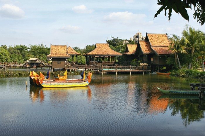 Cultivated park with lake and ancient boats. Houses on stilts. Hotel in Siem reap. Cambodia.